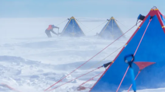 Le Dr Yixi Zheng du British Antarctic Survey enlève la neige de sa tente sur le glacier Thwaites.