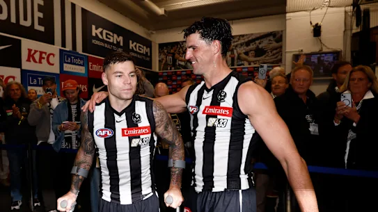 Jamie Elliott et Scott Pendlebury dans les salles après le match.