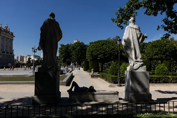 Une femme se repose à l'ombre d'un arbre sur la Plaza de Oriente à Madrid, en Espagne, pendant la canicule du week-end.