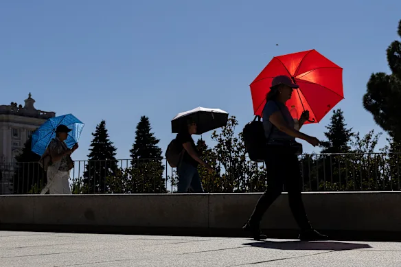 Les gens utilisent des parapluies comme parasols pour combattre la chaleur à Madrid, en Espagne, ce week-end.