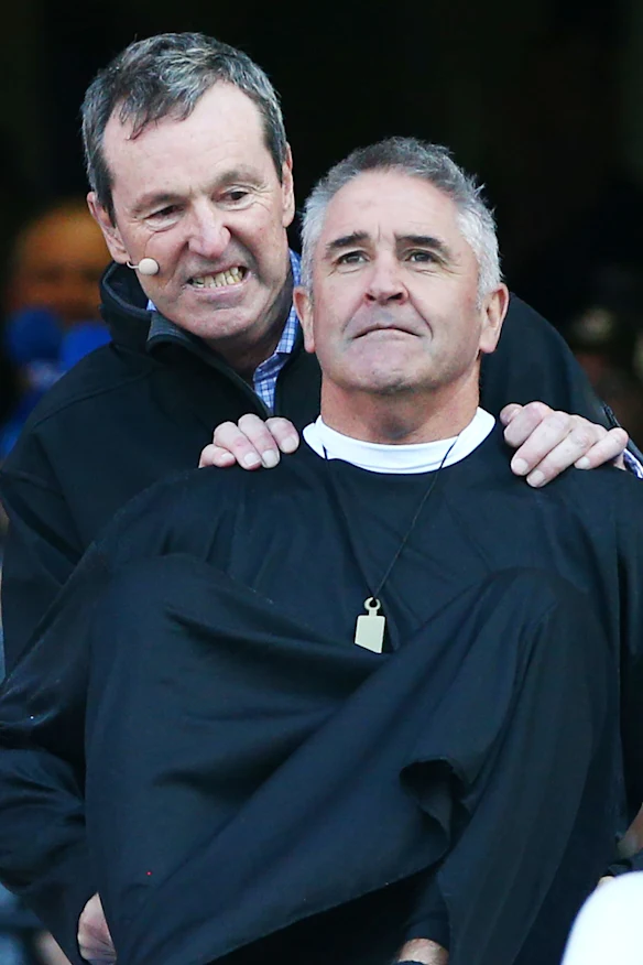 Neale Daniher pousse Chris Fagan sur le toboggan.