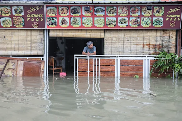 Un homme regarde depuis son restaurant inondé à Legian, Bali, en février.
