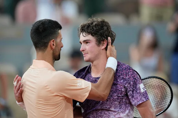 Novak Djokovic embrasse Joao Fonseca après la victoire du jeune.