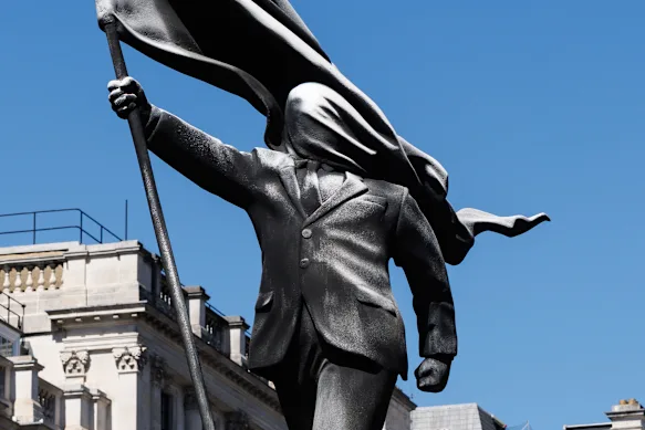 Le dernier pop-up de Banksy est une statue représentant une personne marchant depuis un socle, le visage couvert par un drapeau flottant.