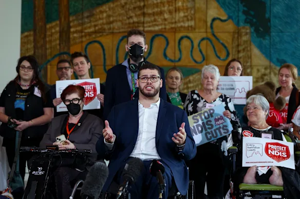 Le sénateur vert Jordon Steele-John aux côtés des défenseurs du NDIS lors d'une conférence de presse post-budgétaire au Parlement.