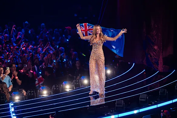 Delta Goodrem portant le drapeau australien pour le défilé des nations lors de la Grande Finale de l'Eurovision.