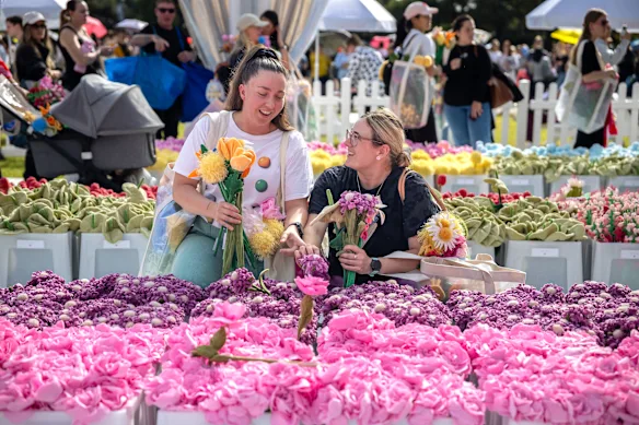 Les amies Sarah Martinuz et Brianna Beckett sélectionnent des fleurs au marché aux fleurs de l'artiste CJ Hendry au domaine vendredi. Le marché aux fleurs est une installation artistique immersive présentant 100 000 fleurs en peluche fabriquées à la main.