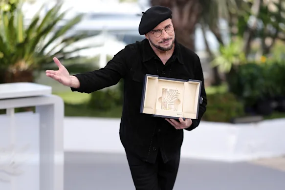 John Travolta avec la Palme d'Or d'honneur qu'il a reçue après la projection de Propeller One-Way Night Coach à Cannes.