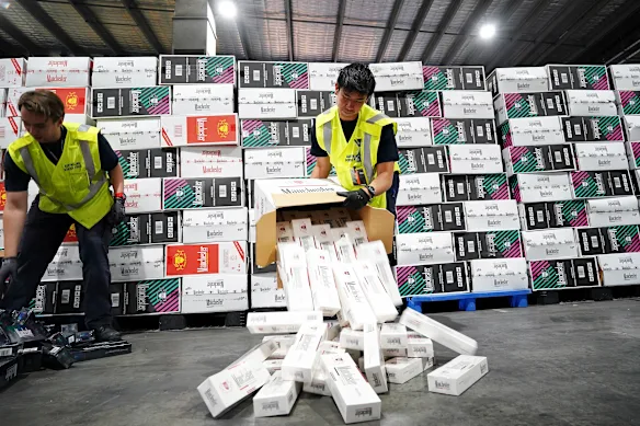 Des agents des forces frontalières australiennes vérifient les importations illégales de cigarettes trouvées dans des conteneurs maritimes à Melbourne l'année dernière.