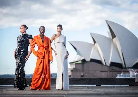 Les mannequins Cameron Stephens, Miji Awakyr et Marisa Pavela portent Carla Zampatti à Circular Quay à Sydney, où la Fashion Week australienne revient lundi.