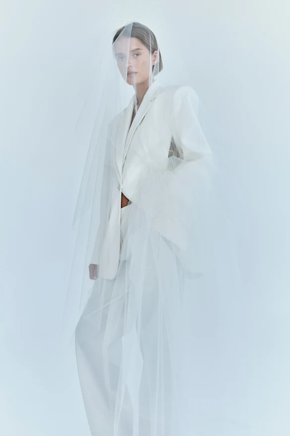 Un costume blanc structuré avec un nœud en mousseline de soie de la collection de mariée du créateur australien Christopher Esber.