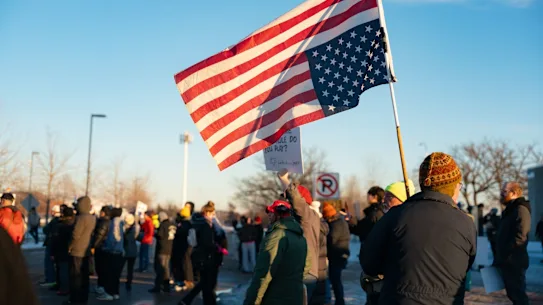 Des manifestants à St. Paul, dans le Minnesota, brandissent un drapeau américain à l'envers pour protester contre le meurtre commis par un agent de l'ICE.