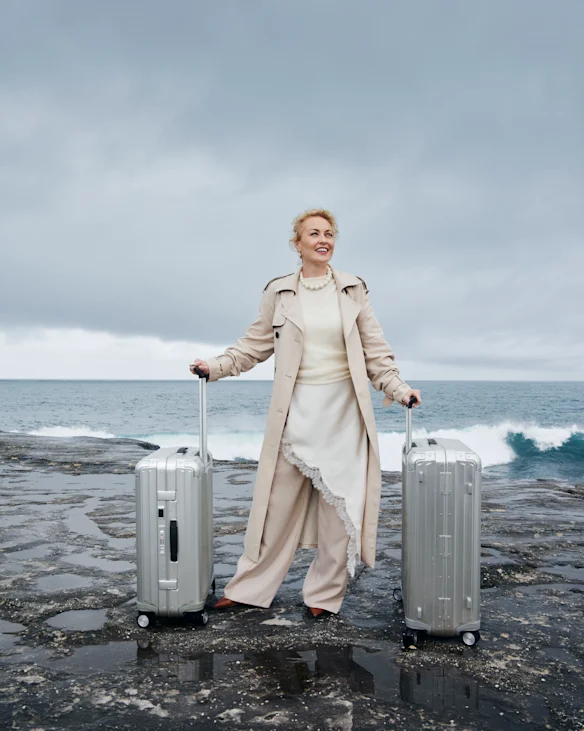 Trench-coat Witchery, robe nuisette et t-shirt en tricot. Pantalon Bianca Spender. Bijoux Dinosaur Designs. Chaussures nues. Valises Samsonite de Strandbags.