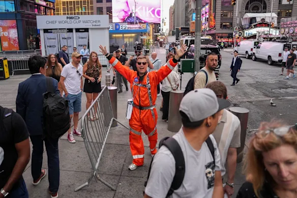 Un piéton porte une combinaison spatiale lors de l'introduction en bourse de SpaceX sur le Nasdaq MarketSite à New York.