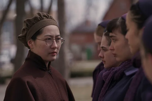 Mabel Li dans l'uniforme restrictif en laine marron de tante Vidala.