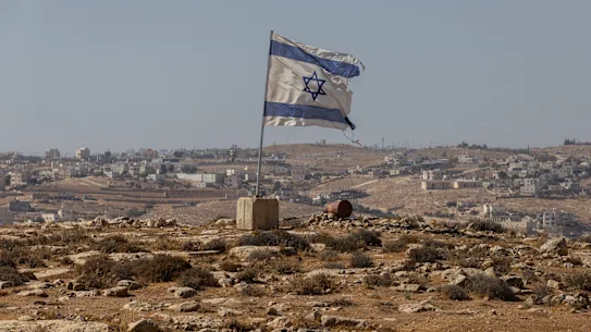 Un drapeau israélien flotte le long d’une autoroute près de la colonie de Carmel en Cisjordanie.