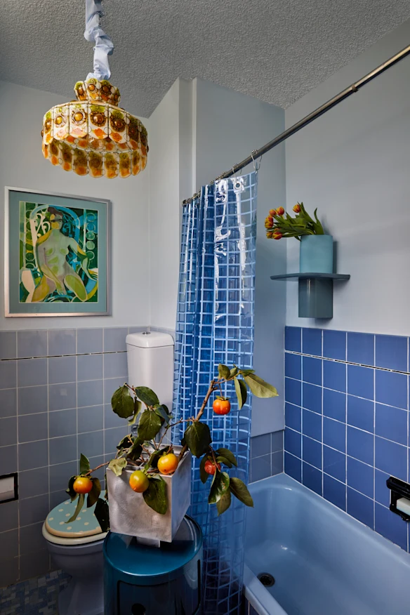 La salle de bain est dans son bleu d'origine. Le meuble de rangement « Componibili » est de Kartell, le vase « Ixia » de Hattie Molloy et le luminaire de Felipe Derflingher pour Feders.