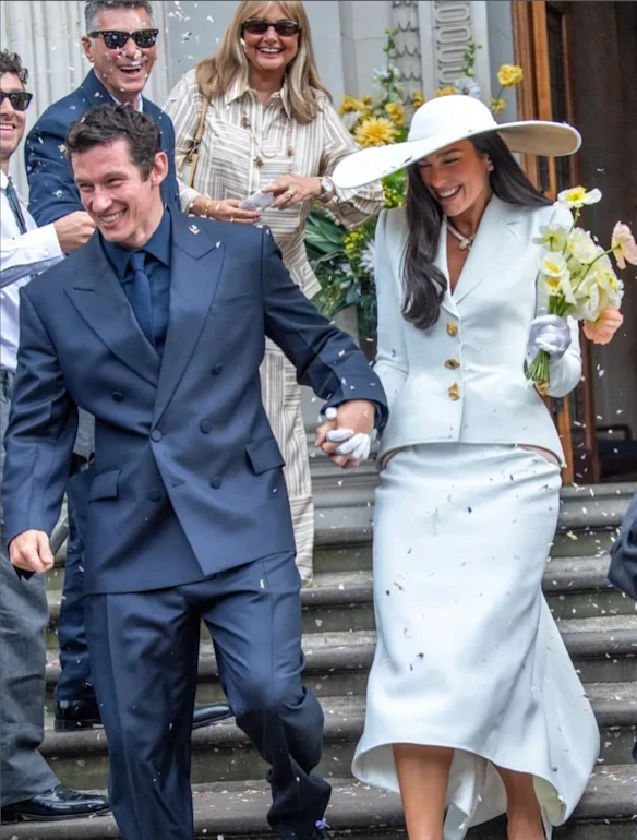 Callum Turner, dans un costume Ferragamo, et Dua Lipa quittant le bureau d'état civil après leur mariage ce week-end.