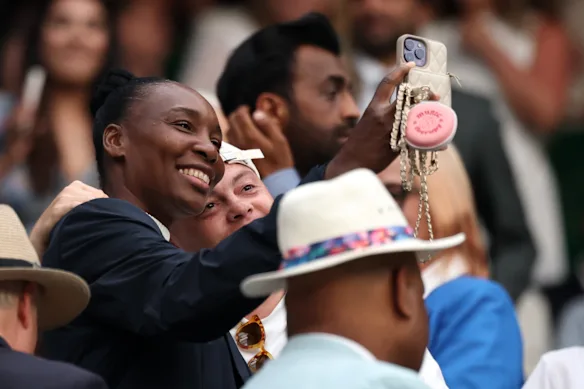 Venus Williams prend un selfie avec un fan tout en regardant sa sœur Serena Williams en action mardi.