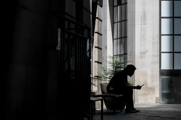 Un homme est assis à l'ombre pendant une canicule dans la City de Londres le 24 juin, le même jour où la London School of Economics a annulé son événement en raison de la chaleur extrême.