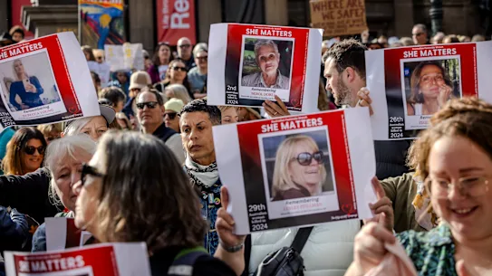 Des gens brandissent des pancartes lors d’un rassemblement national contre la violence à Melbourne en 2024.