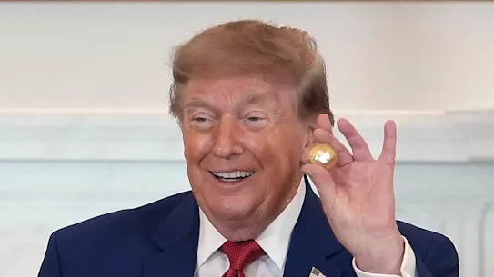 Le président Donald Trump tient une réplique en or massif d'un nodule des profondeurs marines qui lui a été offerte vendredi lors d'une table ronde sur l'exploitation minière américaine.