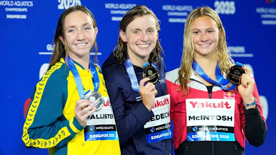 La médaillée d'or du 800 m nage libre Katie Ledecky des États-Unis, au centre, flanquée de la médaillée d'argent Lani Pallister d'Australie, à gauche, et de la médaillée de bronze Summer McIntosh du Canada, à droite.