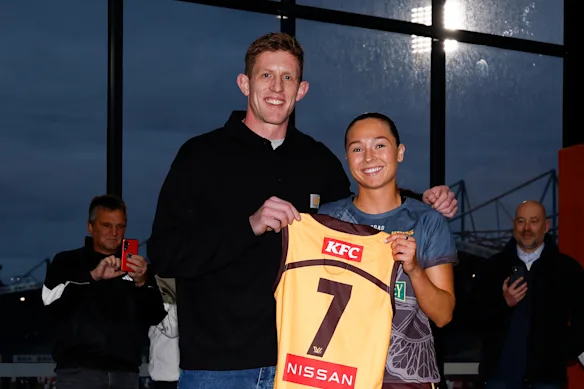 L'ancien joueur des Hawks, Sam Frost, présente à Niamh Martin son pull.