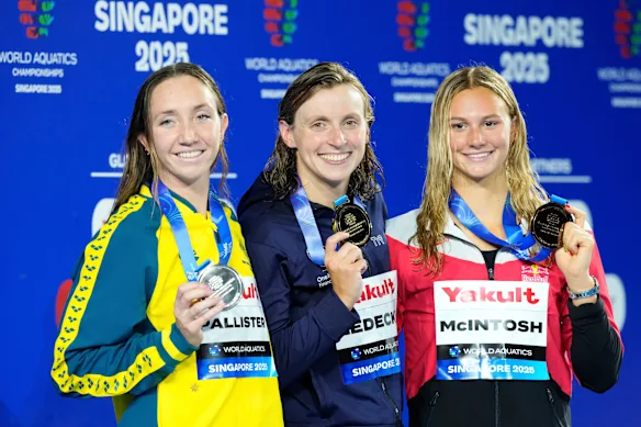 La médaillée d'or du 800 m nage libre Katie Ledecky des États-Unis, au centre, flanquée de la médaillée d'argent Lani Pallister d'Australie, à gauche, et de la médaillée de bronze Summer McIntosh du Canada, à droite.