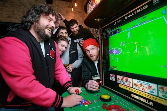 Le créateur du jeu David Ashby, à gauche, et Broden Kelly de Aunty Donna, à droite, font une démonstration de Pro Jank Footy avec l'aide de quelques amis.