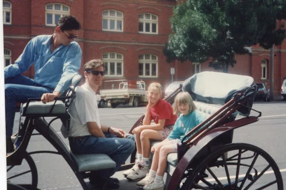 L'écrivain (au centre) avec sa sœur Belinda et son beau-père Ross.