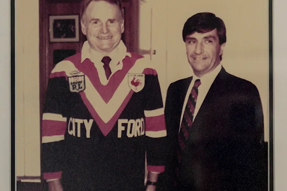 Politis (à droite) avec le président mondial de Ford, Harold « Red » Poling, portant un maillot des Roosters dans les années 1970. 