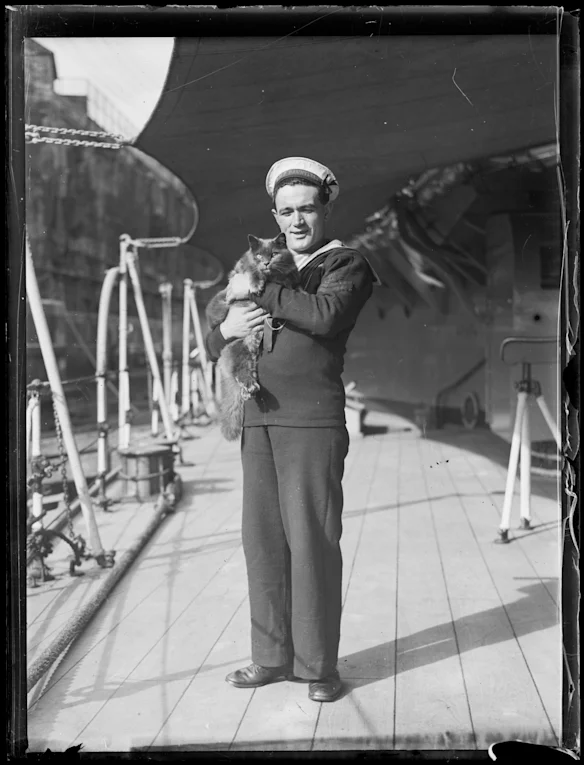 Un marin tenant un chat à bord du HMS Hood, en Nouvelle-Galles du Sud, vers 1934.