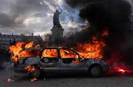 Une voiture est incendiée lors de manifestations à Paris.