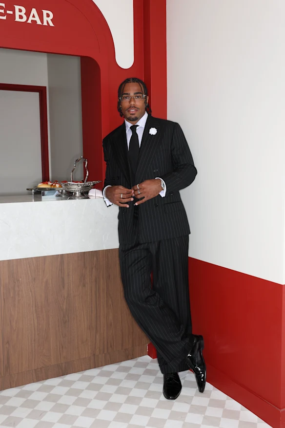 Isaac Quaynor portant un costume à fines rayures Oscar Hunt à l'intérieur du pavillon GH Mumm au Derby Day. 