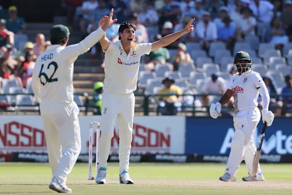Le capitaine australien Pat Cummins et son coéquipier Travis Head revendiquent le guichet du capitaine sud-africain Temba Bavuma, à droite, lors de la troisième journée du troisième match test entre l'Afrique du Sud et l'Australie, au Cap.