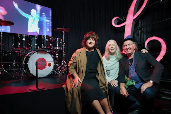 Lex, la fille de Rob Hirst, sa femme Leslie et son camarade du groupe Midnight Oil, Jim Moginie, avec le kit sauvé du batteur. 