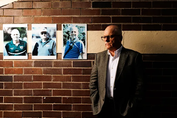 Greg Meagher pose au Coogee Oval avec des photos de son défunt frère Peter Meagher.